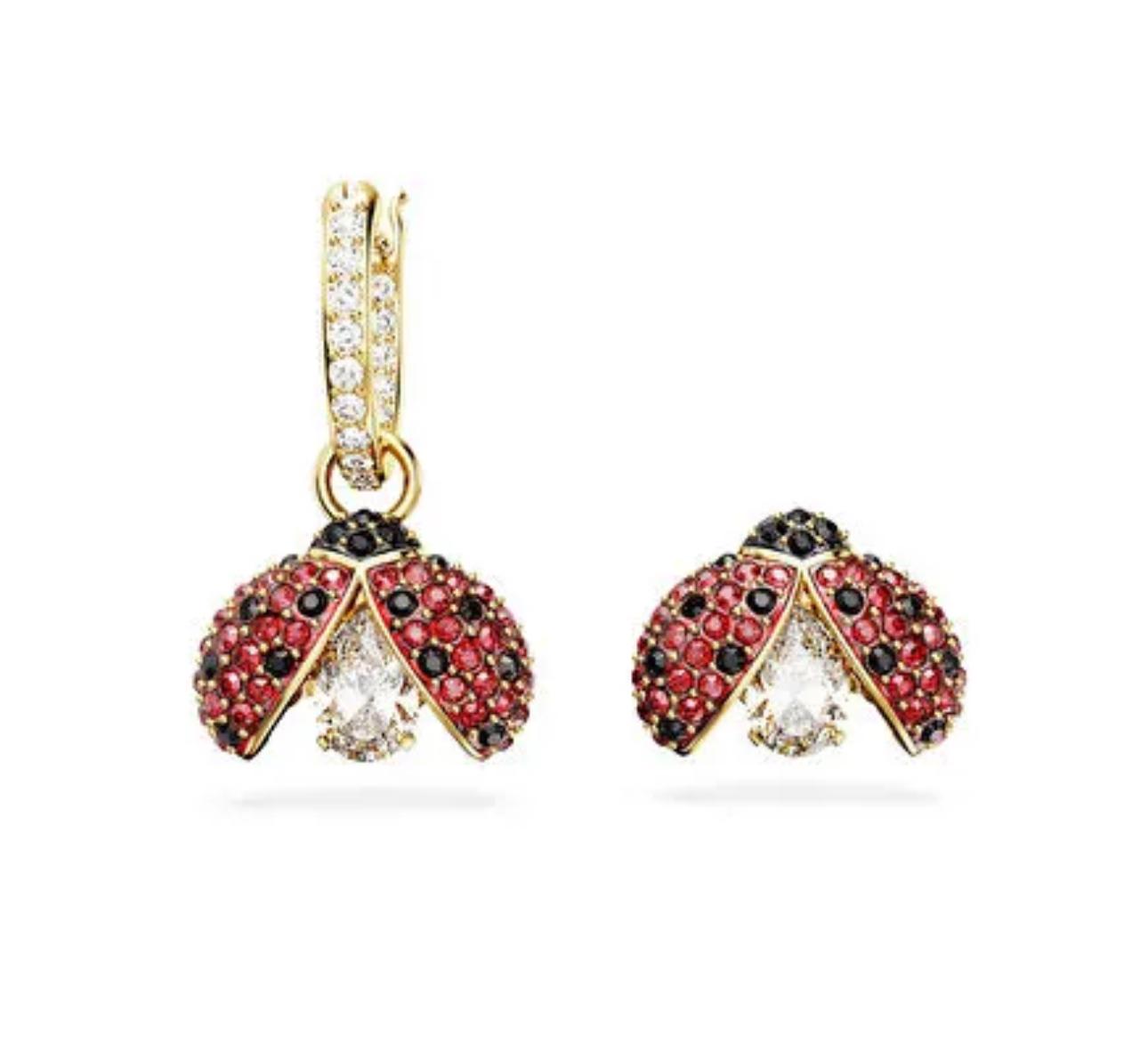 Gold ladybug earrings with red, black, and clear gemstones on a white background