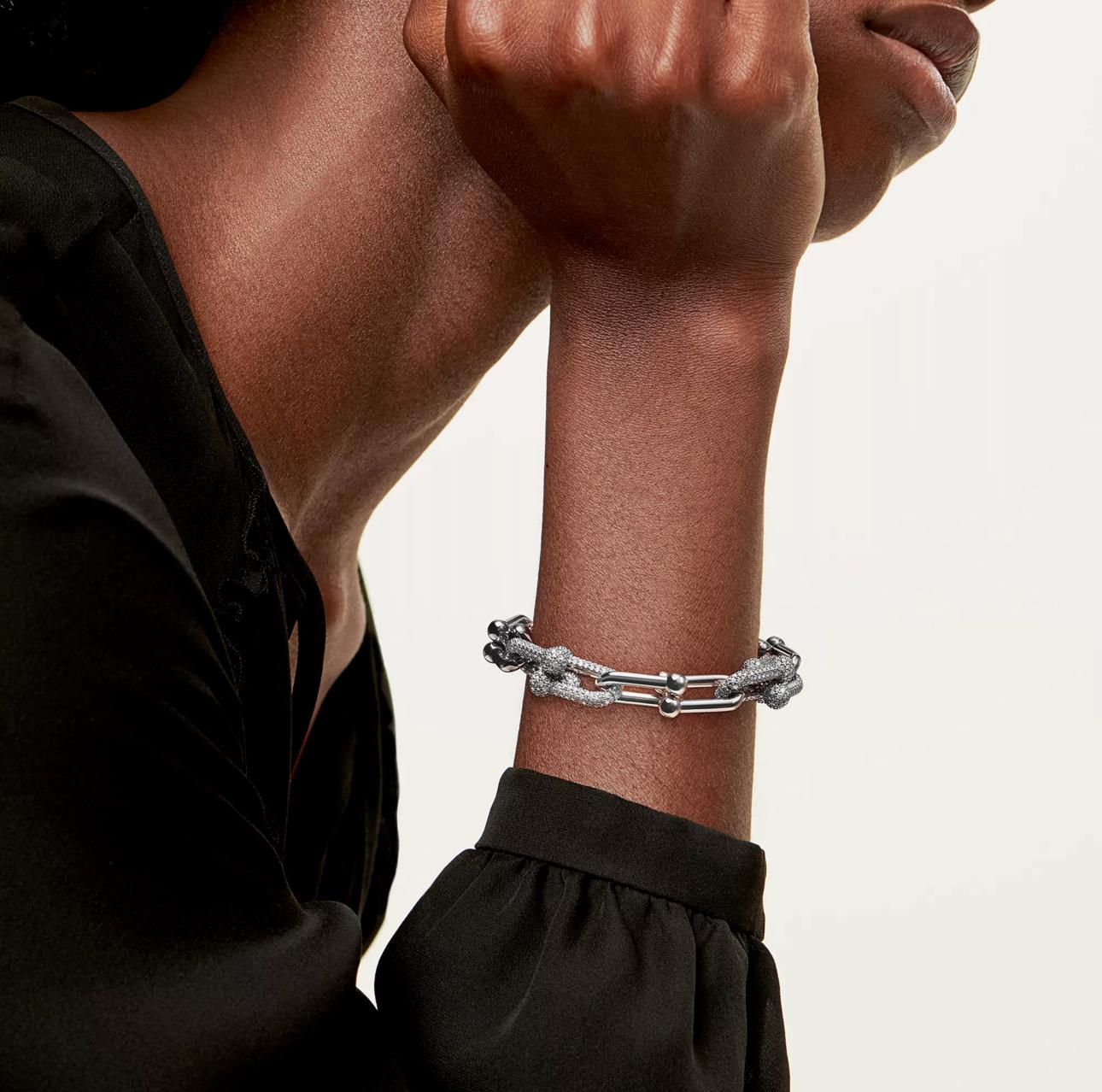 Silver bracelet on a person's wrist with a neutral background