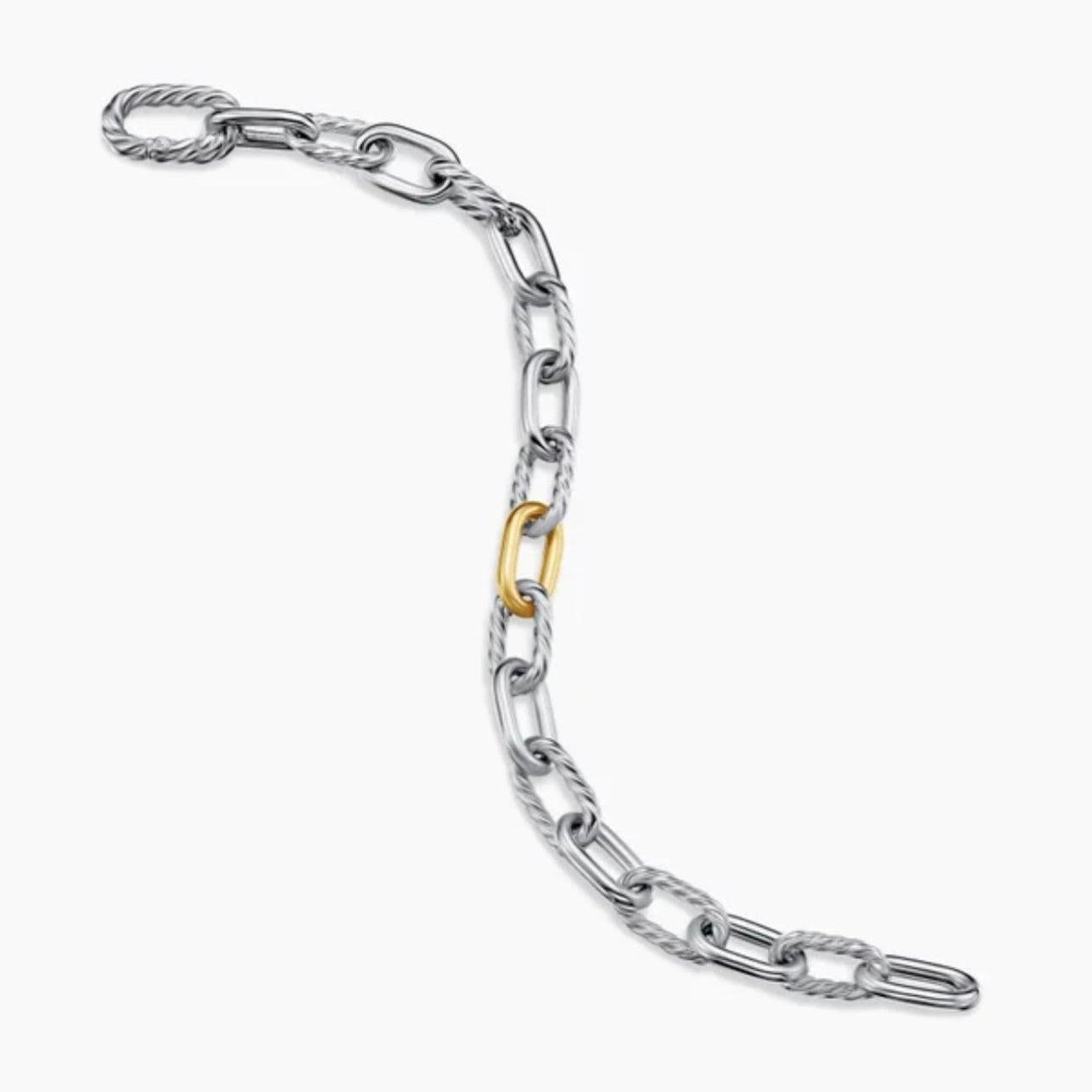 Silver chain bracelet with a gold link on a white background