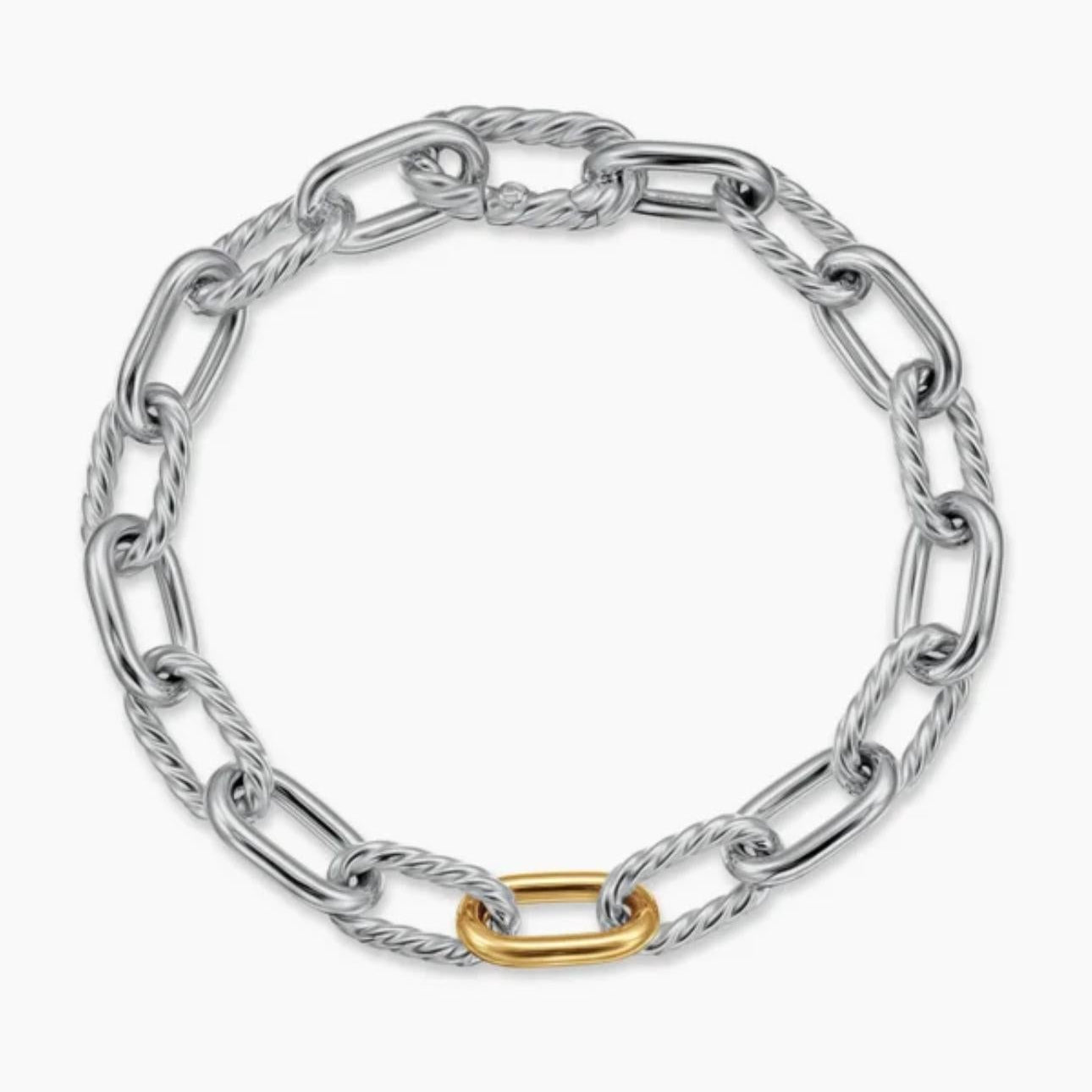 Silver chain bracelet with a gold heart charm on a white background