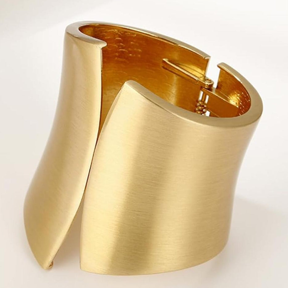 Gold cuff bracelet on a white background