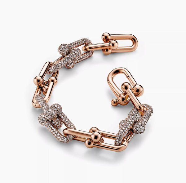 Rose gold bracelet with diamond accents on a white background