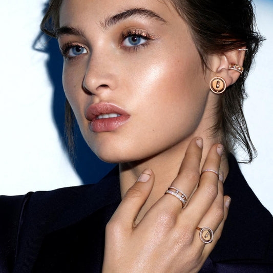 Close-up of a woman wearing gold jewelry with a blurred background