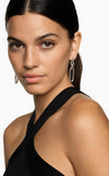 Woman wearing silver hoop earrings with a neutral background