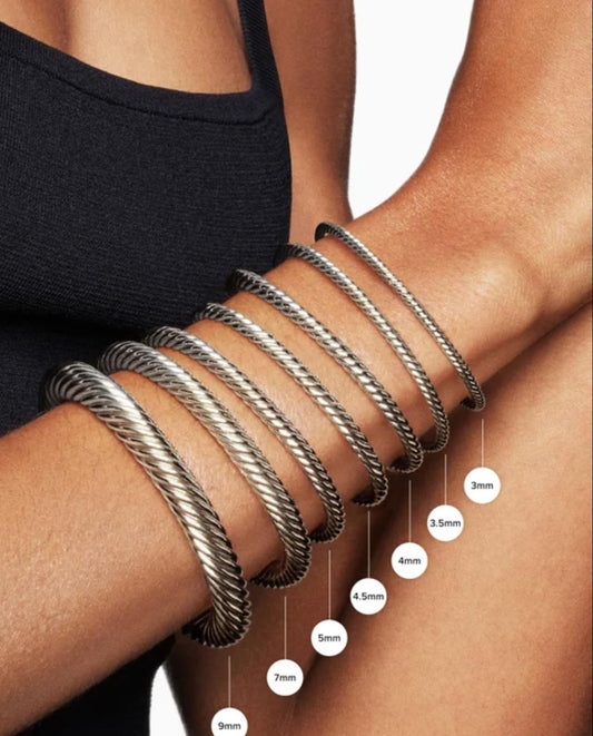 Silver bracelets on a wrist with size measurement labels